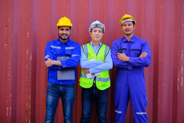 Portrait of three Asian male industry workers with safety uniforms on metal sheet background, arms crossed, looking at camera and smile, cargo shipping, professional freight transportation business.