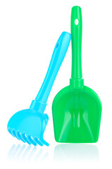 A set of children's toys for playing in the sandbox. Colored rake and shovel made of plastic, isolated on a white background, close-up. Early child development, children's leisure concept