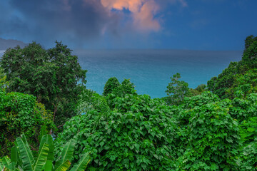 Obraz premium Colourful Skies Sunset over Head Laem Sing Beach in Phuket Thailand. This Lovely island waters are turquoise blue waters, lush green mountains colourful skies and beautiful views of Pa Tong Patong