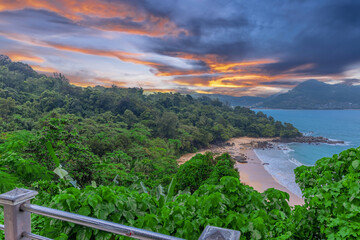 Obraz premium Colourful Skies Sunset over Head Laem Sing Beach in Phuket Thailand. This Lovely island waters are turquoise blue waters, lush green mountains colourful skies and beautiful views of Pa Tong Patong