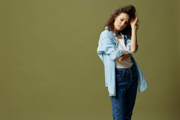 Sad upset curly beautiful female in jeans casual shirt feeling remorse recline on hand posing isolated on olive green pastel background. Being Yourself. People Lifestyle emotions concept. Copy space