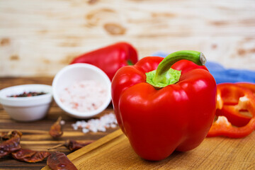 Pepper, tomato, salt, different spice on wooden background
