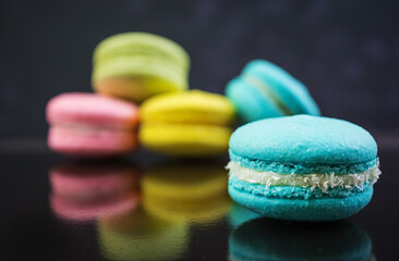 Delicious colorful macaron cakes on dark background
