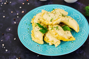Delicious dumplings with cabbage on dark background