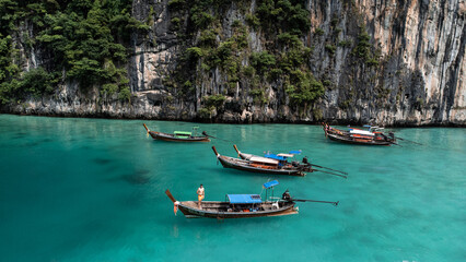 Fototapeta na wymiar Long boats in paradise. Crystal clear waters of the Phi Phi islands. Travel to Thailand