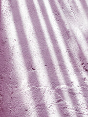 Fototapeta na wymiar A pink wall with sunlight shadows 