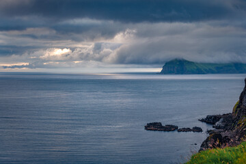 Gloomy evening view from Vagar island plateau, Gasadalur village location. Dramatic summer scene of Faroe Islands, Denmark, Europe. Amazing seascape of Atlantic ocean.