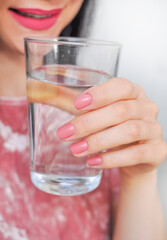 Close up of young woman drinking glass of pure still water