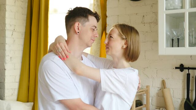 Young loving married couple man and woman hugging looking at camera smiling. teeth with dental braces. Serious and funny attractive faces. Dental healthcare and orthodontic concept. 4 k video