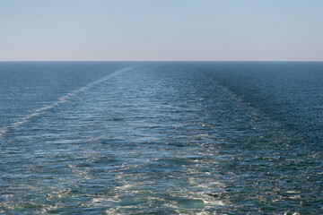 View of wake, kielwater on the blue sea from the board of the ferry.