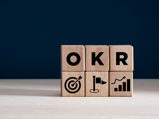 OKR Objectives and Key Results concept on wooden cubes. Business target, growth achievement and...