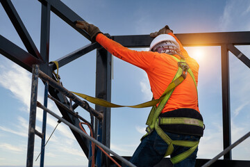 A Construction workers wear safety equipment to prevent falls from heights or Fall arrestor device for worker with hooks for safety body harness on the construction site.