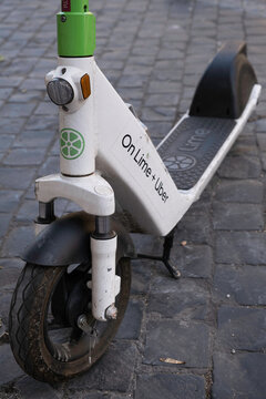 ROME, ITALY - JULY 16 2022: Close-up of the front wheel of an e-step or e-scooter from the company On LIME and UBER for rent in a street in Rome. It is a popular means of transport there, e-mobility