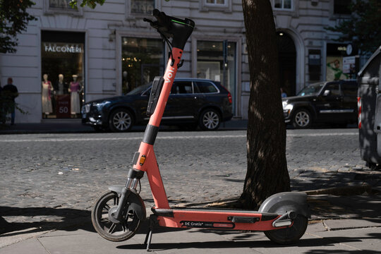 ROME, ITALY - JULY 16 2022: E-scooter or e-step of the company VOI for rent are waiting for customers in a shopping street in Rome. It is a popular means of transport there. E-mobility
