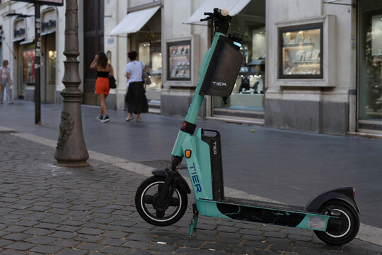ROME, ITALY - JULY 16 2022: E-scooter or e-step of the company TIER in Rome for rent is waiting for customers in a shopping street in Rome. It is a popular means of transport there. E-mobility