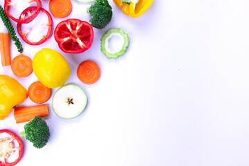Mixed of Healthy food on white background, Natural colorful Healthy vegetarian fruits and vegetables, broccoli, sweet bell chili cut, carrot, green peppers, and lemon