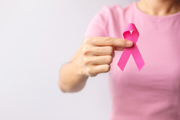 Pink October Breast Cancer Awareness month, woman hand hold pink Ribbon and wear shirt for support...