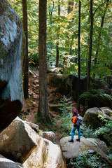 woman traveler with backpack walking by trail in canyon