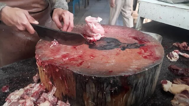 A man selling chicken pieces in the market.