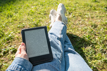 woman hands pov view holding electronic book reading outdoors
