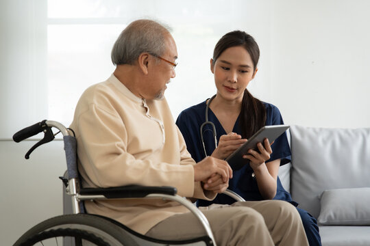 Home Health Care Nurse Caregiver Take Care Senior Elderly Man At Home She Showing The Health Care Madicine Program And Explain The Previous Report To Retirement Old Man 
