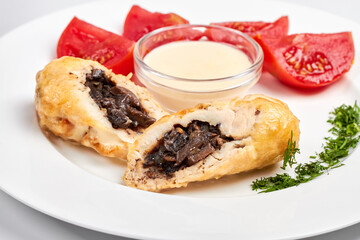 Chicken rolls with mushrooms served with fresh tomatoes, herbs and sauce