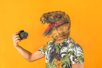 Man using professional camera wearing animal head mask isolated on yellow background.Photographer...