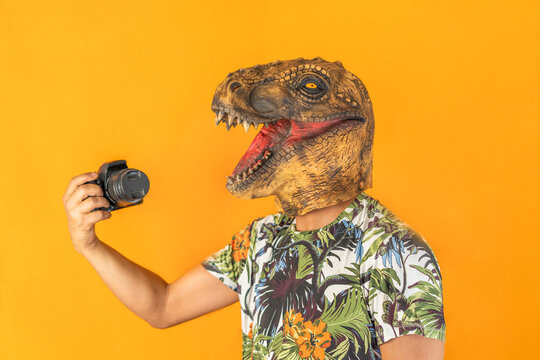 Man using professional camera wearing animal head mask isolated on yellow background.Photographer studio concept.