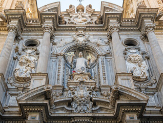 Fototapeta na wymiar Parte alta de la fachada y portada barroca siglo XVIII de la basílica de san Juan de Dios en Granada, España