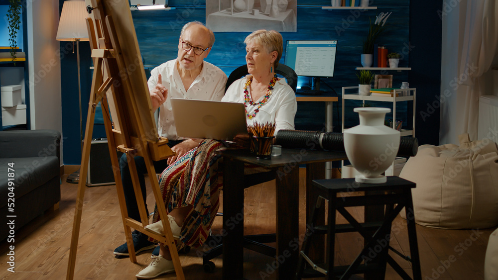 Poster team of senior artists looking at artistic inspiration on laptop, drawing masterpiece sketch with co