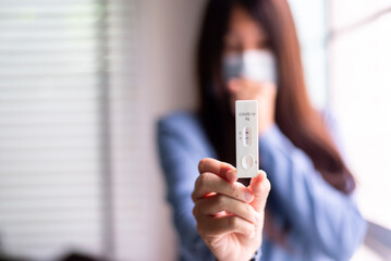 Woman patient holding positive test result for coronavirus or covid 19 at home