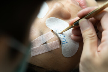 Eyelash extension procedure. woman eye with long eyelashes. lashes. close up, selected focus.