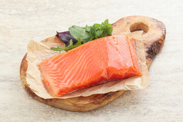 Raw salmon fillet over board