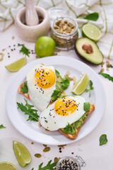 healthy breakfast or snack - sliced avocado and fried egg on toasted bread 