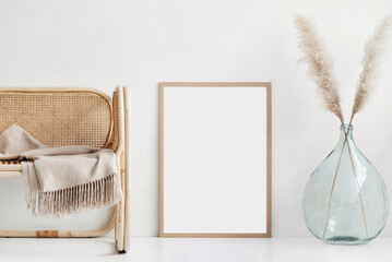 Blank picture frame mockup on white wall. Artwork in minimal interior design. View of modern boho...