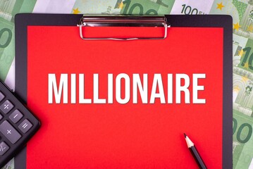 MILLIONAIRE - word on the background of money, a notepad and a pencil with a calculator. Business concept (copy space).