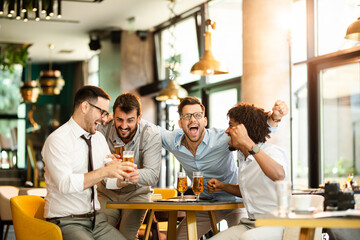 Men at the pub watcing football game and drinking beer.