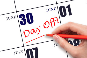 30th day of June. Hand writing text DAY OFF and drawing a line on calendar date 30 June. Vacation planning concept. Summer month, day of the year concept.