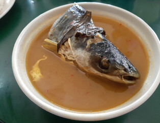 Selective focus picture of Iridescent shark head cook as tempoyak ikan patin.