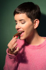 Portrait of the beautiful girl eating chocolate cookies