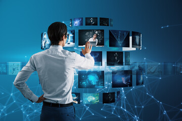 Back view of attractive young european business man with creative digital picture gallery on...