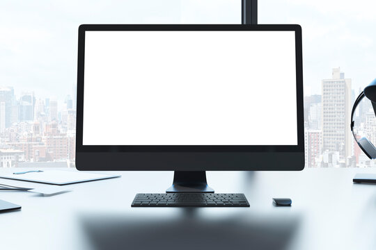 Close up of creative designer desktop with white mock up computer monitor laptop and supplies in modern office with window and panoramic city view. 3D Rendering.