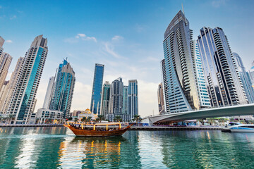 Obraz premium Dubai marina and tourist boat at sunset.