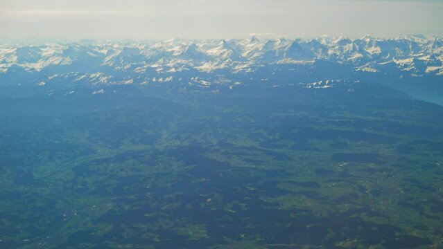 Swiss countryside around the Thun lake with the Alps in the background, aerial view