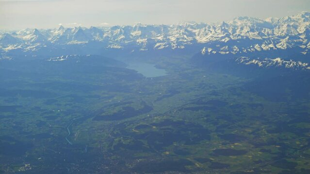 Swiss countryside around the Thun lake with the Alps in the background, aerial view