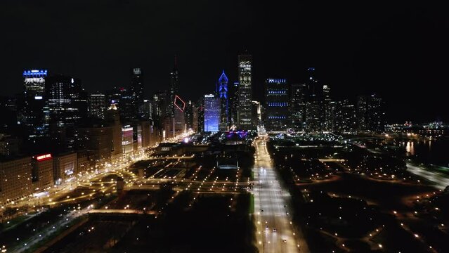 Chicago, Illinois - Night. Long Aerial Establishing Flight Skyline in Background