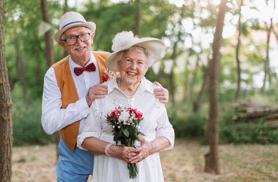 Senior couple having marriage in nature during summer day.