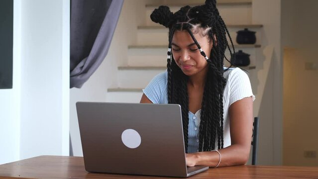 Charming successful young multi-ethnic woman, freelance person, entrepreneur, journalist, copywriter working remotely on laptop, planning projects, running online business from anywhere in the world - Powered by Adobe