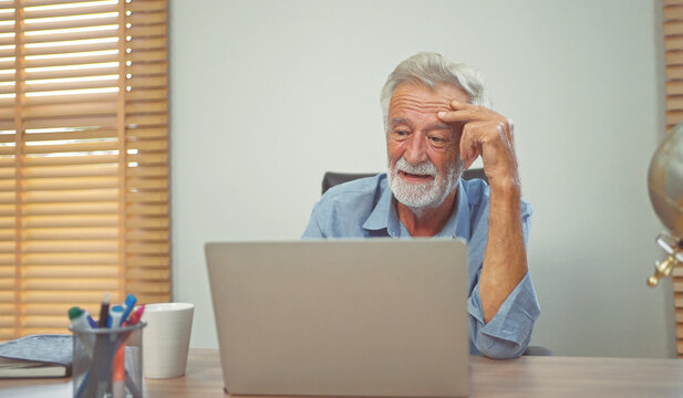 Worried senior man using with laptop computer at home.