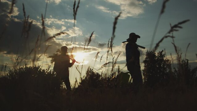Silhouette of diverse group of three people going in field for seeding tree at sunset outdoors. Human responsibility, environmental care, reforestation activity for help nature and health safety